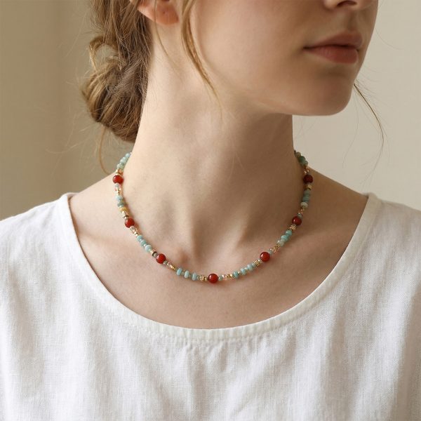 Crystal, black chalcedony, and red agate beaded necklace; handcrafted design featuring colorful beads and contrasting colors.