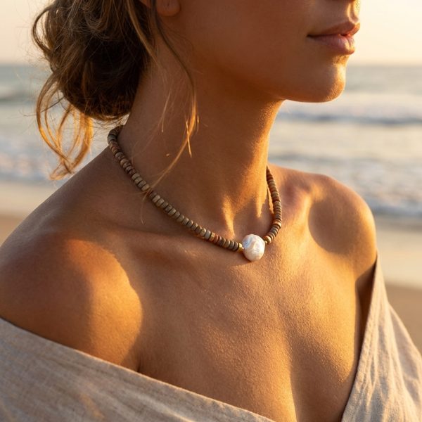 A natural stone necklace with a natural pearl pendant and small stainless steel discs, perfect for everyday wear and a stylish look.